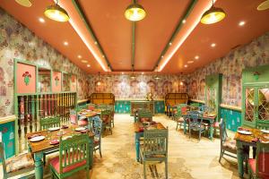 - un restaurant avec des tables et des chaises dans une salle ornée de papier peint dans l'établissement Brilliant Hotel & Convention Centre, à Indore