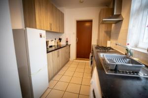 uma cozinha com um lavatório e um frigorífico branco em Sigmalife Apartment em Newcastle upon Tyne