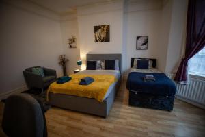 - une chambre avec 2 lits et une chaise dans l'établissement Sigmalife Apartment, à Newcastle upon Tyne