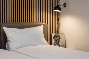 Una cama con una almohada y una foto de un hombre en stadtRaum-berlin apartments, en Berlín