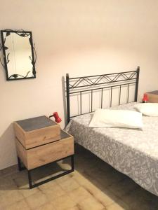 a bedroom with a bed and a dresser with a mirror at ARISTIDIS APARTM. 2 in Kavos