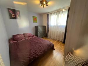 1 dormitorio con 1 cama y una ventana con mariposas en la pared en Aulnay cocoon, en Aulnay-sous-Bois
