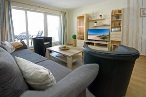 a living room with a couch and a tv at Yachthafenresidenz-Wohnung-9310-900 in Kühlungsborn