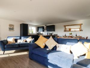 a living room with two blue couches at Bimbling Cottage in Redruth
