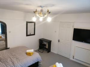 1 dormitorio con 1 cama y TV en la pared en 116 Maison Dieu Road Room A in Dover en Dover
