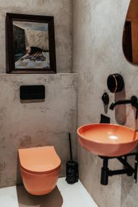 a bathroom with an orange sink and a toilet at TULUM APARTAMENT-Top Design-FREE GARAGE-BATH-Projector-View-GYM-Wine-Next to SPODEK, MCK, NOSPR in Katowice +27 photos