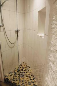 a bathroom with a shower with a checkered floor at Unique Thatched Retreat near Salcombe and Beaches in South Milton