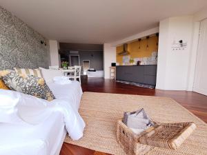 uma sala de estar com um sofá branco e uma cozinha em Aria di Franciacorta em Corte Franca