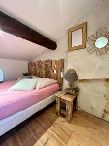 Un dormitorio con una cama y una mesa con una lámpara. en "L'authentique" Maison de ville Arles La Roquette, en Arles