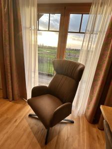 einen Stuhl in einem Zimmer mit Fenster in der Unterkunft Laupus-Hof in Bad Vilbel