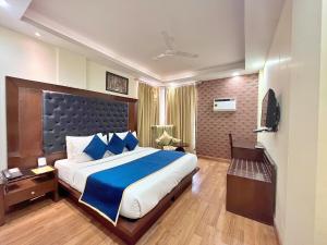 Habitación de hotel con cama grande y TV en The Grand Orion - Kailash Colony en Nueva Delhi