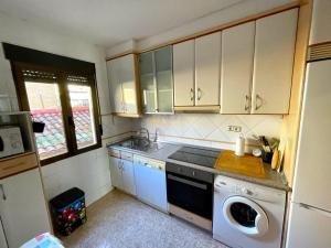 a kitchen with white cabinets and a dishwasher at Antequera3 in Zaragoza