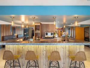 une grande cuisine avec un bar et des tabourets dans l'établissement ibis Styles Marennes d'Oléron, à Marennes