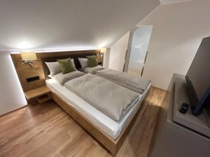 ein Schlafzimmer mit einem großen Bett mit weißer Bettwäsche und grünen Kissen in der Unterkunft Laupus-Hof in Bad Vilbel