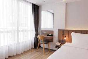 a bedroom with a bed and a desk with a chair at Pure Eleven Hotel Bangkok in Makkasan