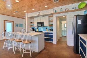 Una cocina con gabinetes blancos y un refrigerador negro. en No Shoes No Shirt No Problem, en Port Aransas