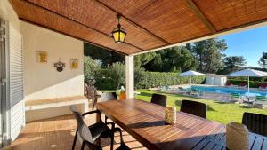 un patio al aire libre con mesa de madera y sillas en Sol by Check-in Portugal, en Vilamoura