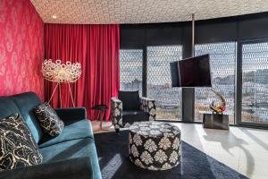 a living room with a couch and a tv at Barceló Raval in Barcelona