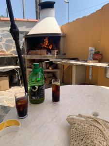 een tafel met twee glazen en een fles en een oven bij Villa Maria Mercedes in Olesa de Bonesvalls
