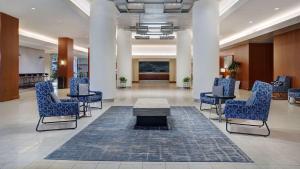 a lobby with chairs and a table in the middle at Hyatt Regency DFW International Airport in Dallas