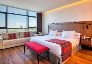 マドリードにあるオンリー ユー ホテル アトーチャの大きなベッドとソファが備わるホテルルームです。