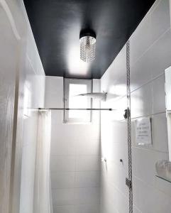 een badkamer met een douche en een plafond met een licht bij (3P)Gerard Diva House in Huancayo