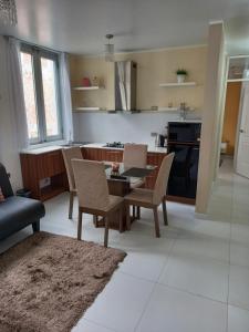 een keuken en een woonkamer met een tafel en stoelen bij (3P)Gerard Diva House in Huancayo