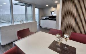 a dining room with a white table and red chairs at schwimmendes Ferienhaus Sky in Elsterheide