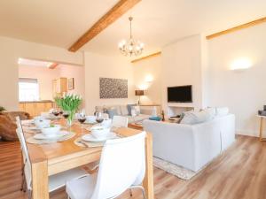 a dining room and living room with a table and chairs at Feathers, Blythburgh in Halesworth