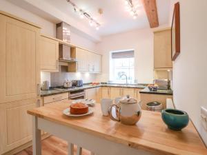 a kitchen with a wooden table with a tea pot on it at Feathers, Blythburgh in Halesworth