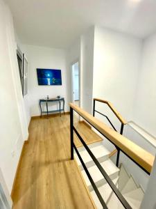 Habitación blanca con escaleras y mesa. en Casa Mimi By Solymar Holiday, en Vélez-Málaga