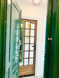 a green door in a room with a window at Cosy T2 in Neuilly sur Seine metro 1 in Neuilly-sur-Seine