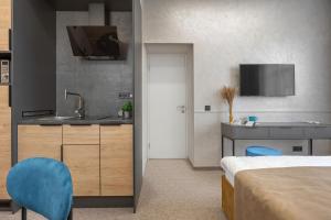 um quarto de hotel com uma cama e um lavatório e uma cozinha em Jam Apartments Lviv em Lviv