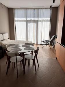 sala de estar con mesa, sillas y cama en Sea Breeze Resort, Lighthouse2 seaside studio apartment, en Baku