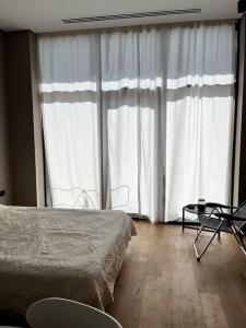 1 dormitorio con cama y ventana grande en Sea Breeze Resort, Lighthouse2 seaside studio apartment en Bakú