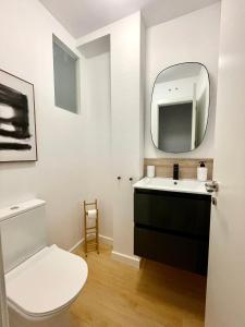 y baño con aseo blanco y espejo. en Home Las Burgas D&C, en Ourense