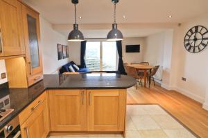 eine Küche mit Holzschränken und ein Esszimmer in der Unterkunft APARTMENT BY THE BEACH, courtyard garden in Saint Merryn