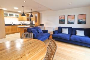 a living room with a blue couch and a table at APARTMENT BY THE BEACH, courtyard garden in St Merryn