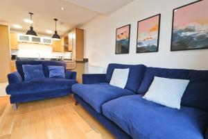 um sofá azul e duas cadeiras numa sala de estar em APARTMENT BY THE BEACH, courtyard garden em Saint Merryn