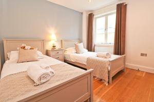 a bedroom with two beds and a window at APARTMENT BY THE BEACH, courtyard garden in St Merryn