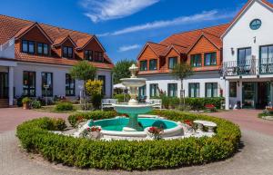 a fountain in a courtyard in front of a building at Ferienwohnungen an den Salzwiesen in Boltenhagen