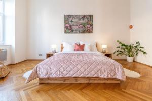 a bedroom with a large bed with a wooden floor at Stylish luxury flat in Old Town in Staré Mesto