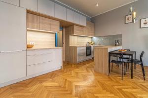 a kitchen with white cabinets and a table and chairs at Stylish luxury flat in Old Town in Staré Mesto