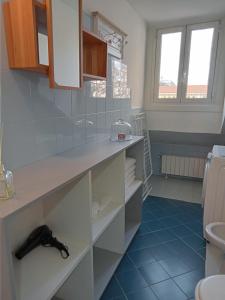 a bathroom with white cabinets and blue tile floors at La Mole apartment in Turin