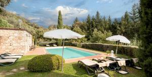 einen Pool mit Sonnenschirmen und Stühlen neben einem Pool in der Unterkunft Casetta di Butia, Gelsomino Apartment in Borgo a Mozzano