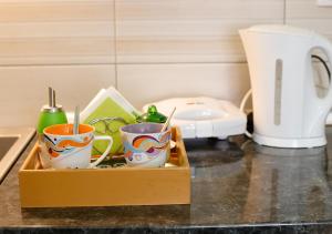 a wooden tray with cups on a kitchen counter at Apartman Teo in Lukavica