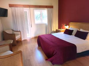 um quarto com uma cama grande e uma janela em Ribeirotel em Albergaria-a-Velha
