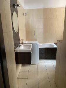 a bathroom with a tub and a sink and a bath tub at Hostel Rynek22 in Gliwice