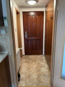 - un couloir avec une porte en bois dans une maison dans l'établissement Bernadett Villa Apartman 3, à Bük