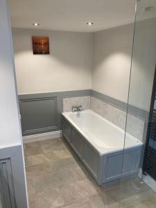 a bathroom with a bath tub and a shower at RedBayBeach-House in Glenariff